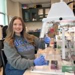 Keely Dunham poses while working at a genetics lab bench. on July 12, 2024